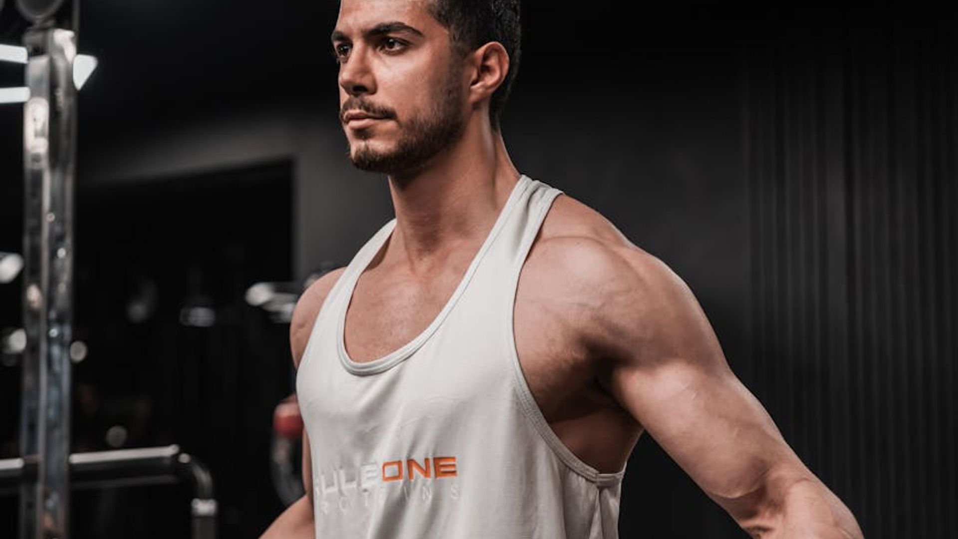 Athletic man focused on his training routine in a dark gym