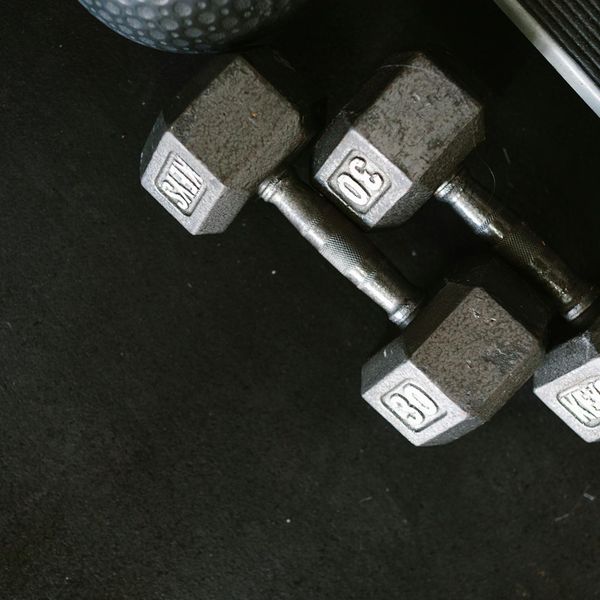 Pair of heavy black dumbbells on a dark mat